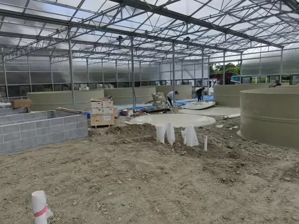 Partially completed floor and equipment inside a framed building.