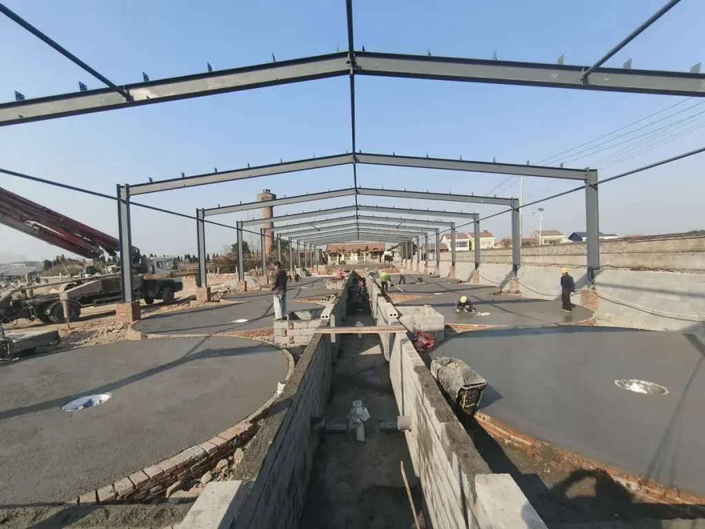 Concrete tank bases and a central channel inside the unfinished facility.